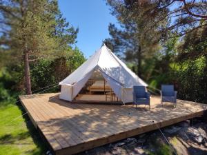 a white tent with chairs on a wooden deck at Anniksson Glamping Telk- Loodustelk in Virtsu