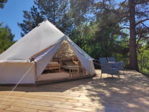 a white tent with chairs on a patio at Anniksson Glamping Telk- Loodustelk in Virtsu +8 photos