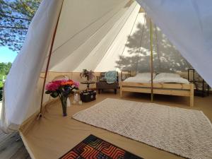 a tent with a bed and a vase of flowers at Anniksson Glamping Telk- Loodustelk in Virtsu