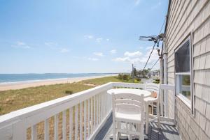 a balcony with a table and chairs and the beach at Waves Oceanfront Resort in Old Orchard Beach