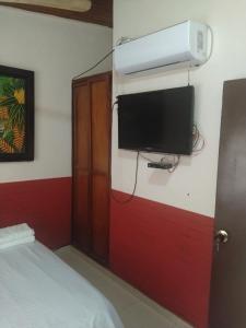 a room with a bed and a tv on a wall at Habitación Doble, Baño Privado, 4 Cuadras Del Rodadero, Zonas Comerciales in Gaira