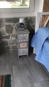 a bed room with a night stand and a window at La Casa di Manu in Lessona
