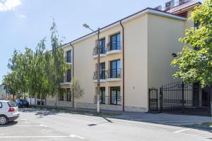 an apartment building with a car parked in a parking lot at Hotel Anina in Techirghiol