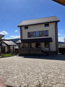 a house with a brick driveway in front of it at Villa OkSun in Skhidnitsa