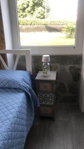 a bedroom with a bed and a nightstand next to a window at La Casa di Manu in Lessona +10 photos