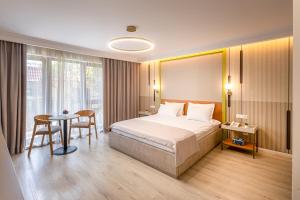 a hotel room with a bed and a table at Hotel Anina in Techirghiol +50 photos