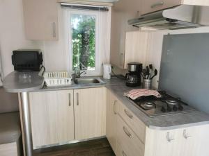 a small kitchen with a stove and a sink at Camping du Pontis in Verteillac