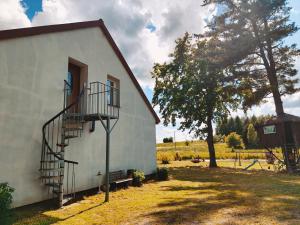 a building with a spiral staircase next to a tree at Stary Dom in Kandyty