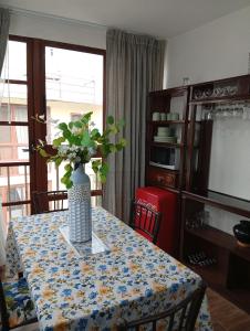 a dining room table with a vase of flowers on it at Cómodo departamento en Xochimilco in Mexico City +10 photos