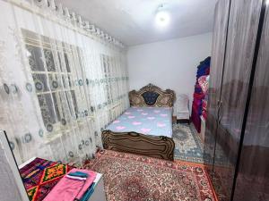 a bedroom with a bed in a room with curtains at Nur-Nomad in Balykchy