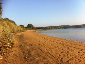 a sandy beach next to a body of water at Gite de Kergrist in Paimpol