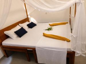 two beds in a room with white sheets and pillows at Beach Cab Resort in Arugam Bay