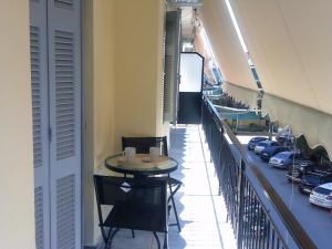a balcony with a table and chairs and cars at ΑΚ City Apartment 1 in Ágios Rókkos