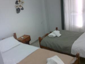 two beds in a hotel room with towels at ΑΚ City Apartment 1 in Ágios Rókkos