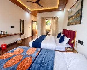 a bedroom with two beds and a ceiling fan at The Chapter Stay - Kedarnath in Phata +4 photos