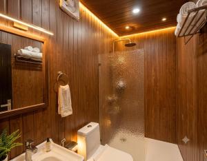 a bathroom with a shower and a toilet and a sink at The Chapter Stay - Kedarnath in Phata