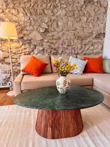 a living room with a table with a vase on it at Portail Sainte Marie in Montbrun-les-Bains