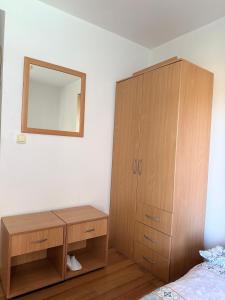 a bedroom with a wooden cabinet and a mirror at Splendid corner in Bečići