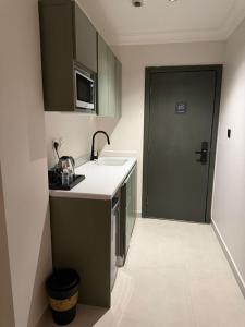 a small kitchen with a sink and a door at Studio in South Khobar in Al Khobar