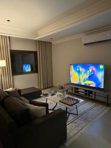a living room with a couch and a large screen tv at Studio in South Khobar in Al Khobar