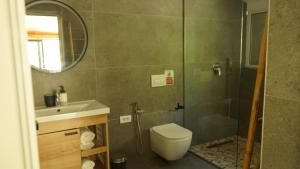 a bathroom with a toilet and a sink and a shower at Life on Green in Himare +60 photos