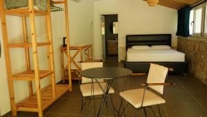 a bedroom with a bed and a table and chairs at Life on Green in Himare