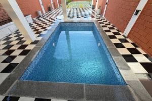 a swimming pool with blue water on a checkered floor at Vihaalaya stays in Tozhuppedu