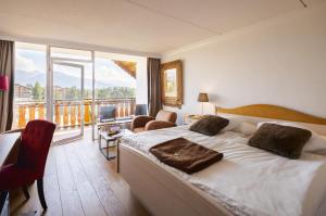 a hotel room with a bed and a large window at Hotel Etrier in Crans-Montana +43 photos