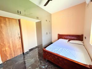 a small bedroom with a bed and a mirror at Vihaalaya stays in Tozhuppedu +32 photos