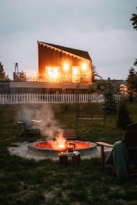 a fire pit in a yard with a house in the background at Kwiatowisko in Szewnia
