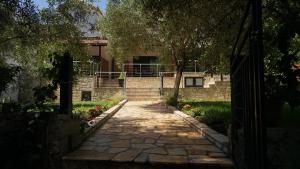 a stone walkway in front of a house with trees at Life on Green in Himare