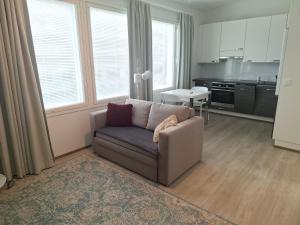 a living room with a couch and a kitchen at Apartment Songhill in Kuopio
