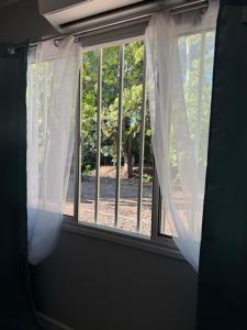 a window with white curtains in a room at Family Wolf - El Chorro in Paquera
