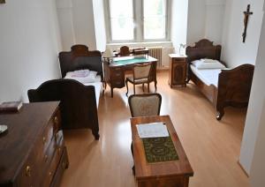 a room with beds and a table and a desk at Zisterzienserstift Lilienfeld in Lilienfeld +5 photos