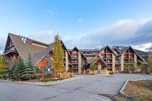 a large apartment building with a parking lot at Stunning Mountain Views - Pool&HotTub - King Bed - BBQ in Canmore