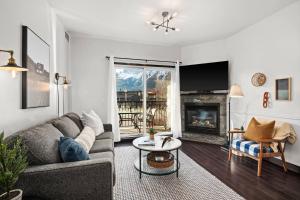 a living room with a couch and a fireplace at Stunning Mountain Views - Pool&HotTub - King Bed - BBQ in Canmore