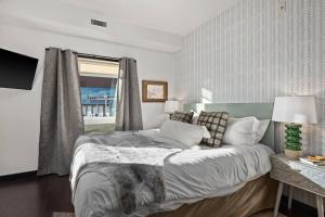 a bedroom with a large bed and a window at Stunning Mountain Views - Pool&HotTub - King Bed - BBQ in Canmore +47 photos
