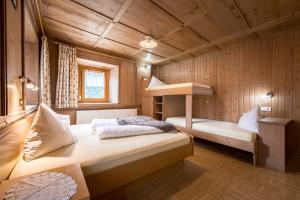 a bedroom with two beds in a wooden cabin at Oberwirt in Selva dei Molini