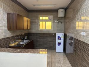 a kitchen with a sink and a refrigerator at رحيانه ابها in Abha