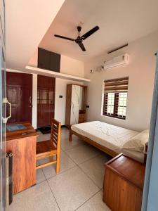 a bedroom with a bed and a ceiling fan at Lakeside Meadows- Diamond Homestay in Kollam