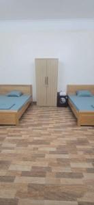 two beds are in a room with a wooden floor at Cô tô xinh in Quang Ninh