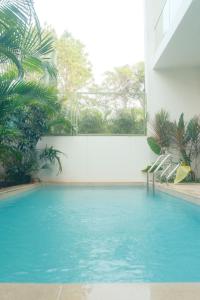 a swimming pool with blue water in a building at Aura Stays L8 in Vagator
