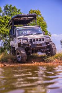 a jeep parked next to a body of water at Buddika Safari & Resort in Udawalawe