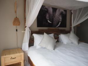 a bedroom with a bed with white sheets and pillows at Keiskama B & B in Port Elizabeth +45 photos