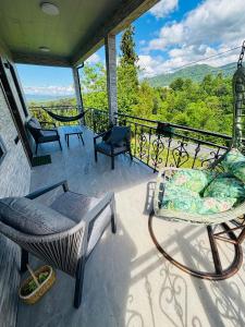 a porch with a couch and chairs on a balcony at Green Villa in Kobuleti