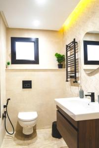 a bathroom with a white toilet and a sink at Dar Mustapha in Tunis