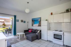 a living room with a couch and a kitchen at Akrotiri apartment in Pefkochori