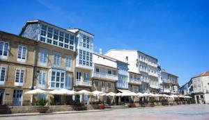 a row of buildings with umbrellas on a street at Casa Plaza do Millo in Celanova
