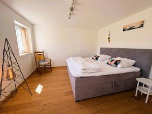 a small bedroom with a bed and a chair at Ferienwohnungen Hopfenhaus in Spalt