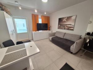 a living room with a couch and a flat screen tv at Apartment Songhill in Kuopio
